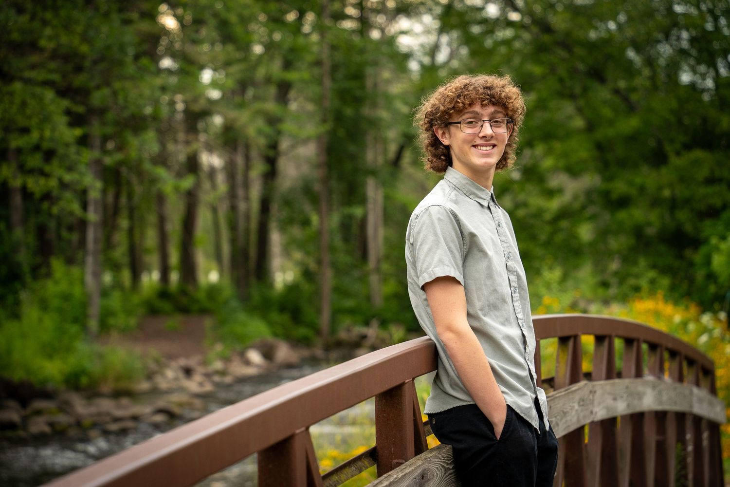 Wisconsin Senior and Portrait Photographer - Boy smiling on a bridge in Wisconsin during a summer senior portrait session.