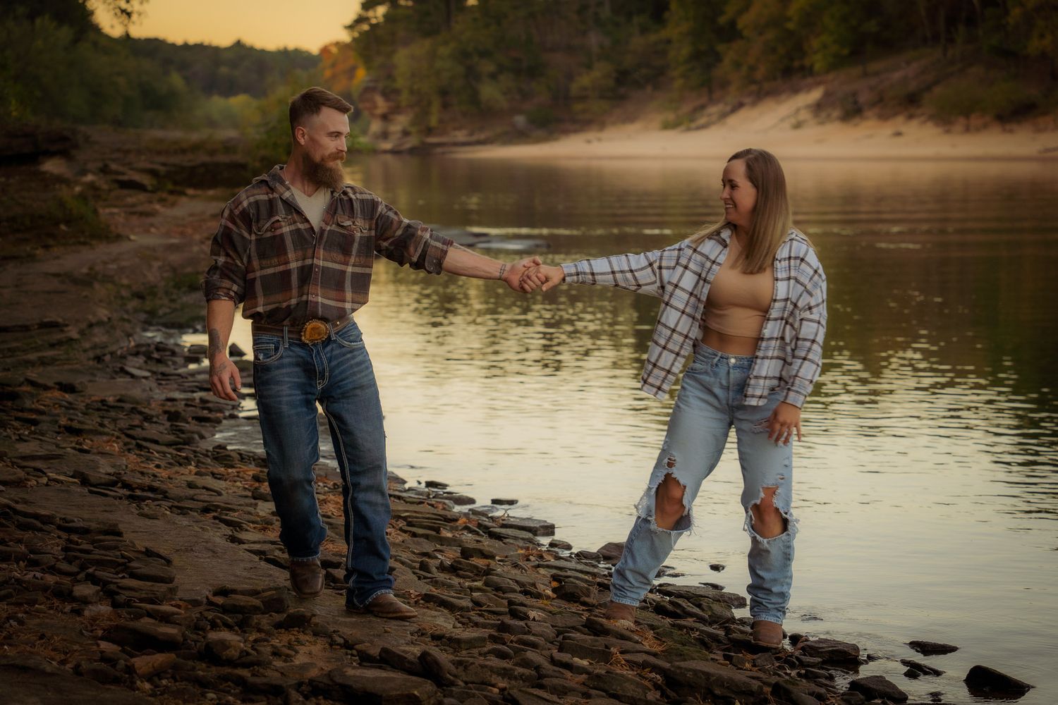Wisconsin Couple and Engagement Photographer - Couple walking on riverbank in fall during engagement session in Wisconsin during sunset.