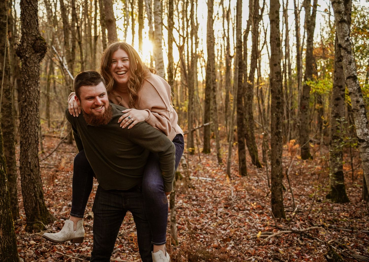 Wisconsin Couple and Engagement Photographer - Couple laughing in woods in fall during an engagement session during sunset in Wisconsin.