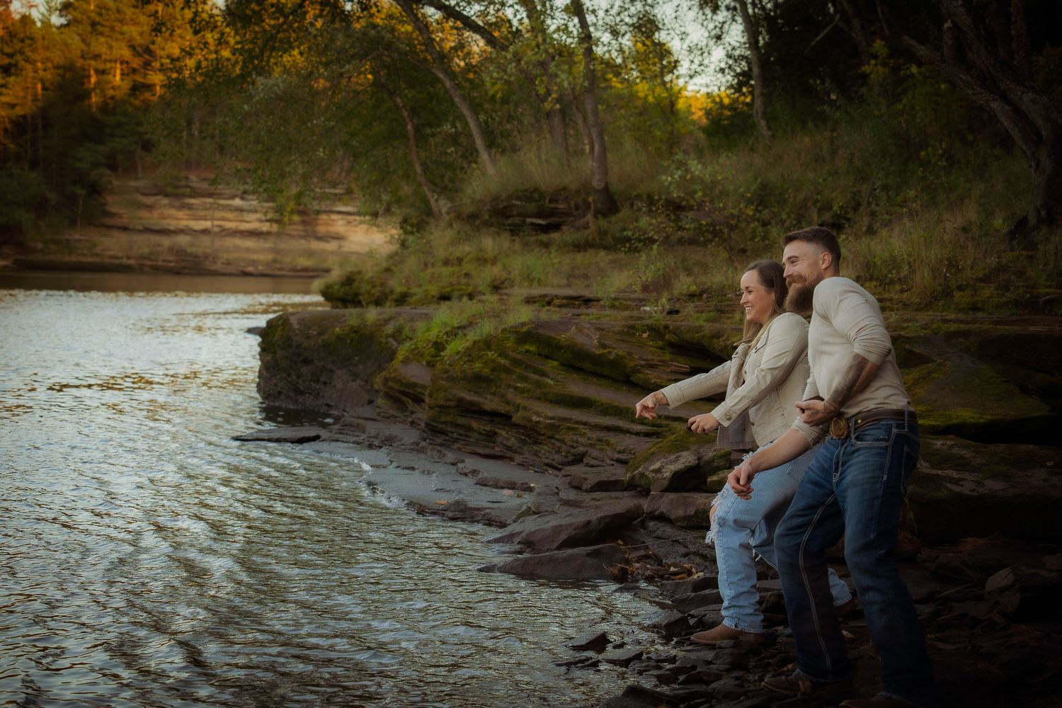 Wisconsin Couple and Engagement Photographer - Couple skipping rocks in fall during an engagement session in Wisconsin during sunset.