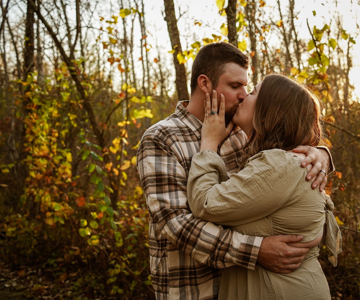 Wisconsin Couple and Engagement Photographer - Couple kissing in woods in fall during an engagement session during sunset in Wisconsin.