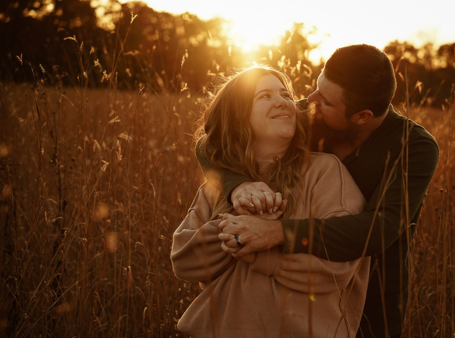 Wisconsin Couple and Engagement Photographer - Couple hugging in a field in fall during an engagement session during sunset.