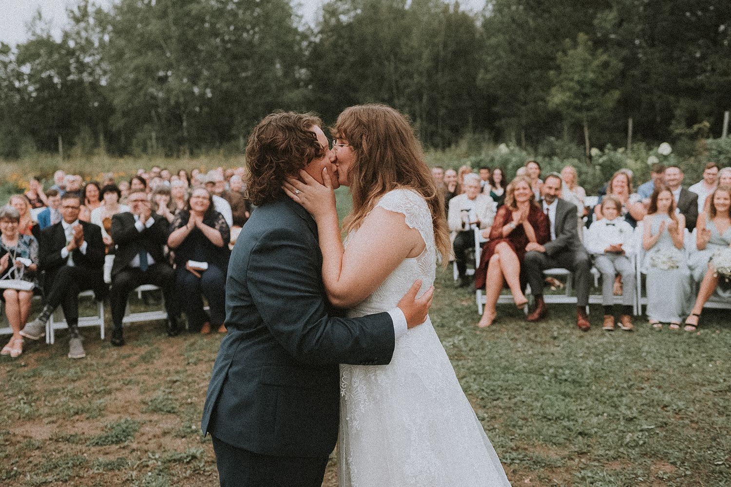 Wedding celebration with guests seated outdoors watching a couple share their first dance.