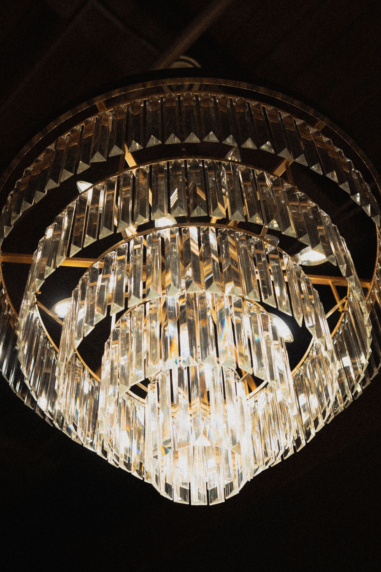 Close-up of an ornate crystal chandelier with geometric patterns against dark background at Le Venere wedding venue in Saint Paul Minnesota