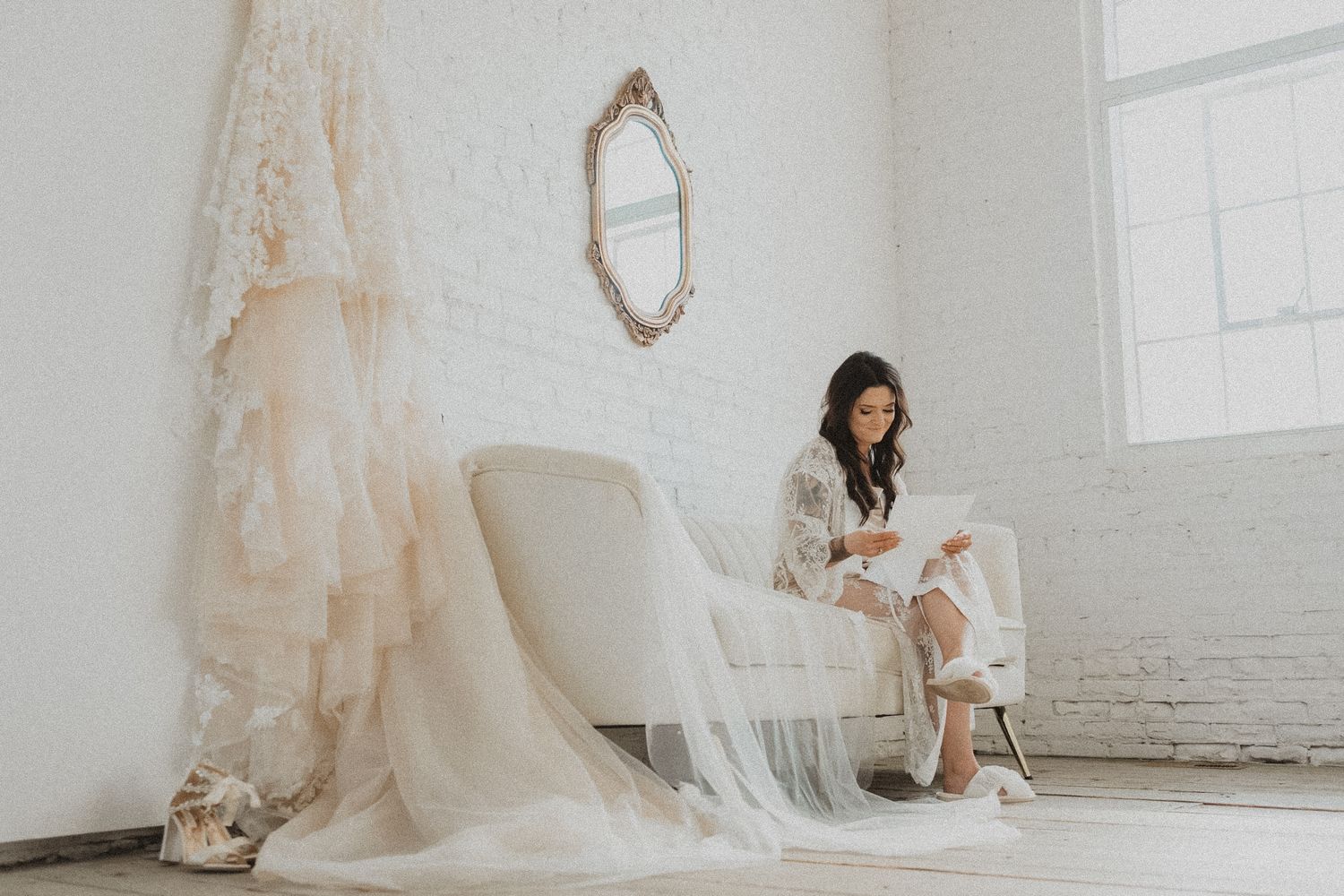 A serene bridal preparation scene in an all-white room with vintage decor reading vows at Northern Pacific Weddings and Events
