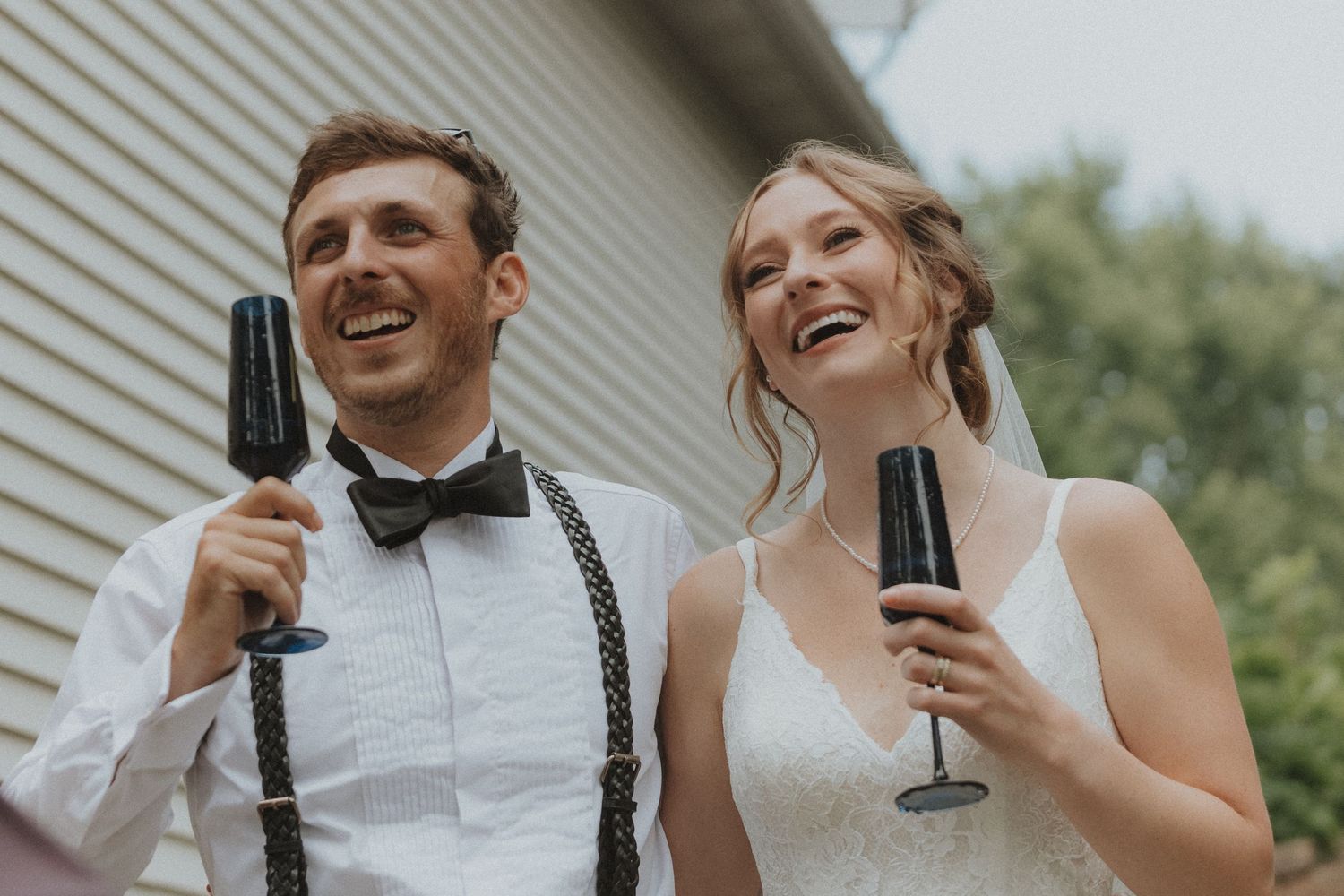 Wedding Bride & Groom laughing and toasting with champagne glasses outdoors Wiconia Minnesota