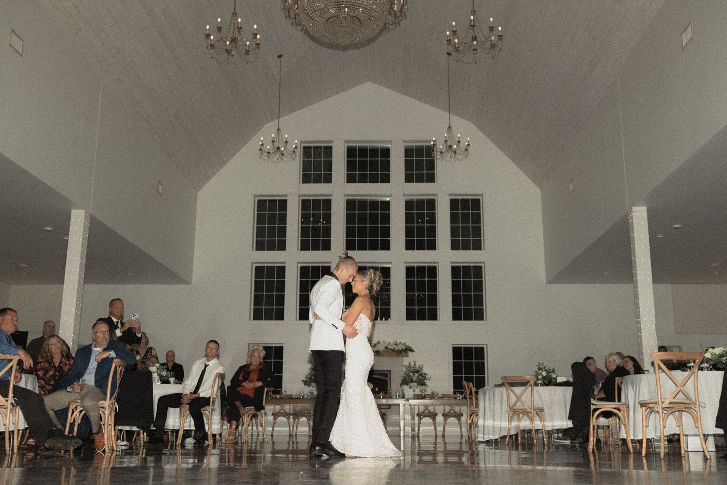 A couple shares their first dance in an elegant white chapel reception venue at Abella in Chisgo City MN