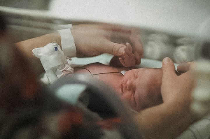 Medical monitoring equipment being used in a hospital room setting. Dads hands holding nicu baby
