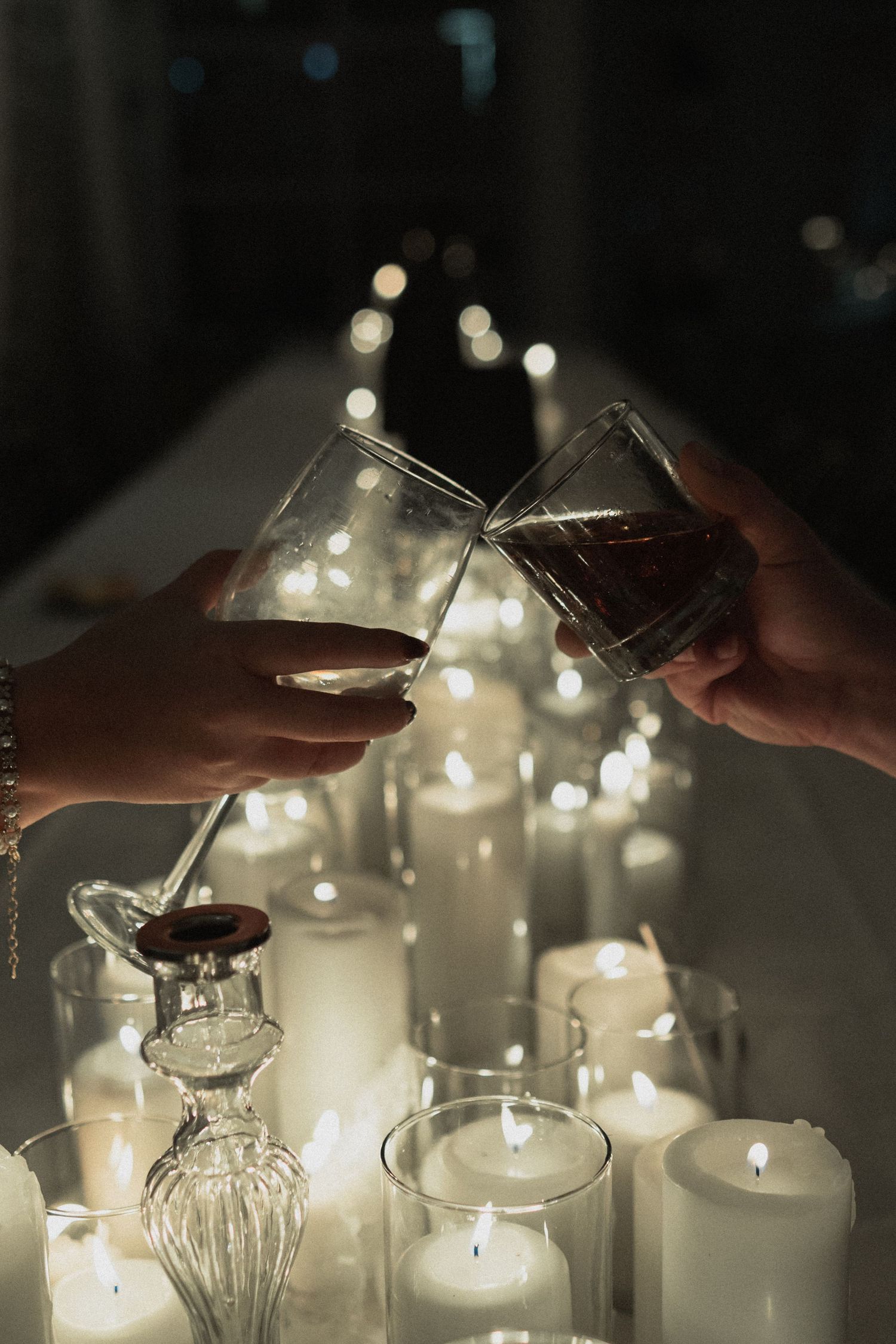 Wine glasses clinking in romantic candlelight with bokeh effects at Astor Cafe in Minneapolis Minnesota. Cheers for the bride and groom