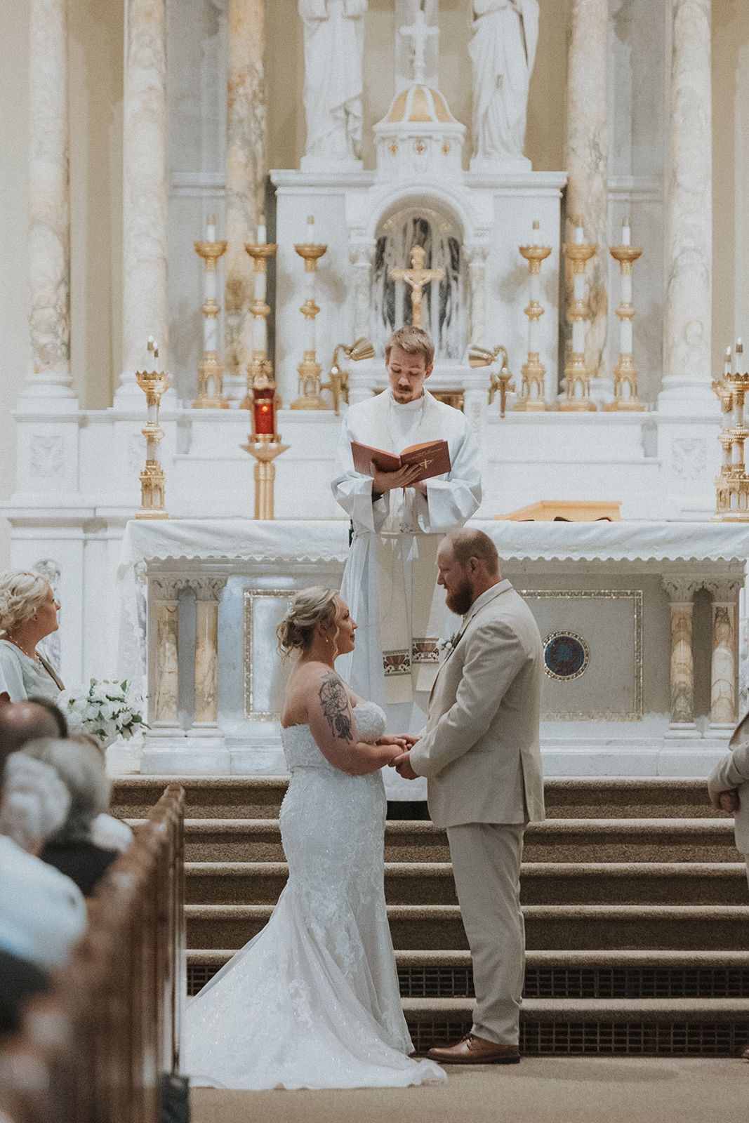 Wedding ceremony in progress inside ornate white cathedral with classical architecture small town Minnesota