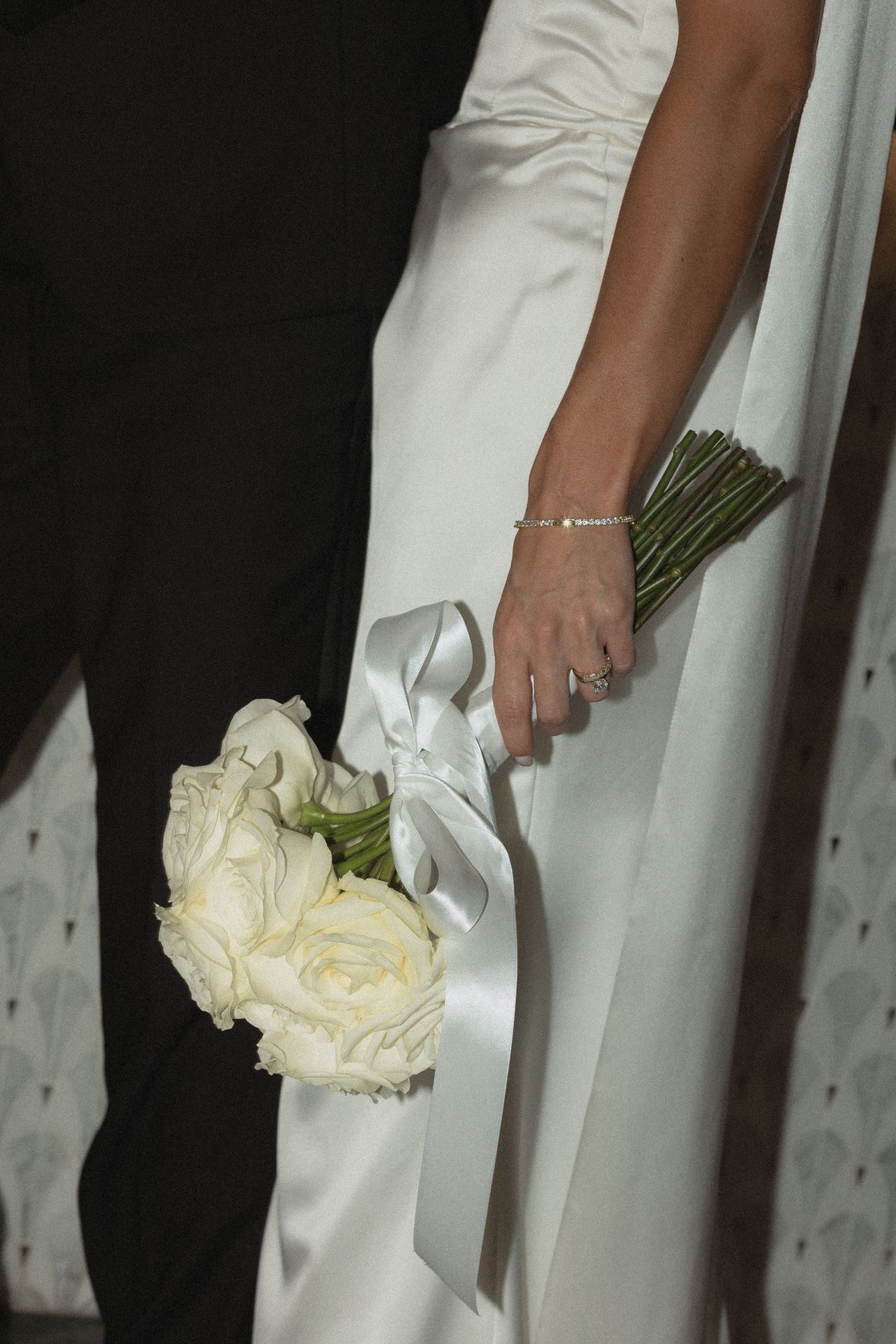Detail shot of white wedding dress and bouquet of cream roses direct flashat Le Venere wedding venue in Saint Paul Minnesota