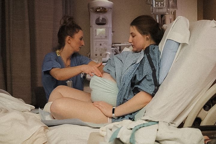 Casual lifestyle moments of pregnant mother captured in an indoor hospital setting with natural lighting.