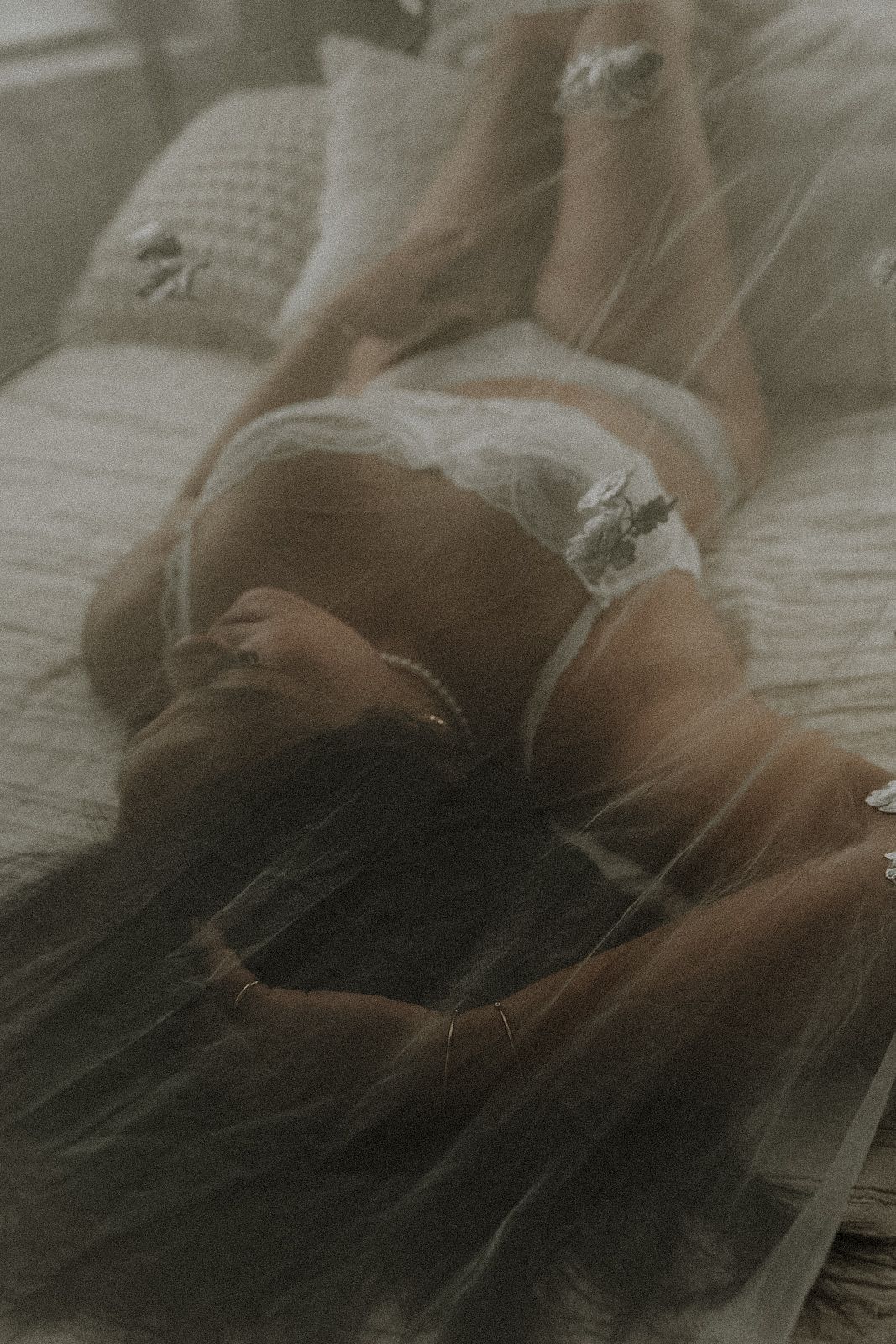 Dreamy bridal boudoir photography with soft focus and ethereal lighting under bride veil