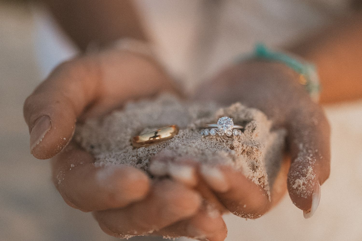 Close up of hands covered in beach sand and sparkles at Secrets Akumal Mexico resort wedding