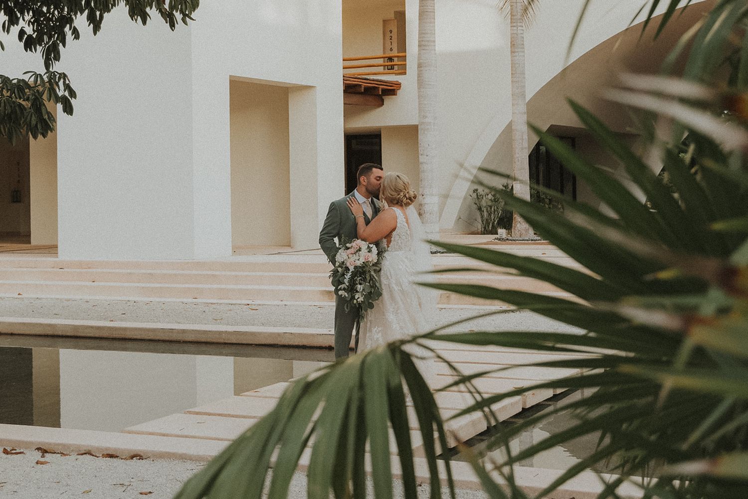 Elegant white drapery and palm fronds create a romantic tropical wedding ceremony setting at Secrets Akumal Mexico resort wedding
