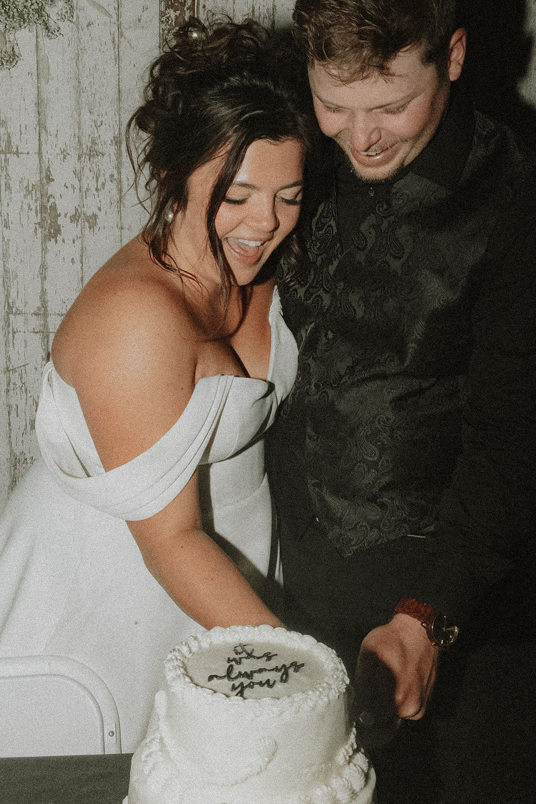 Happy newlyweds sharing a moment while cutting their wedding cake in Minnesota