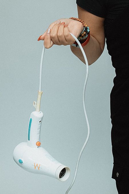 White blowdryer being held at different angles against a light background.
