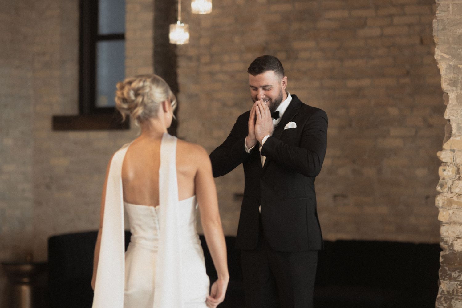A romantic first look moment between newlyweds in an industrial brick venue Le Venere Saint Paul Minnesota