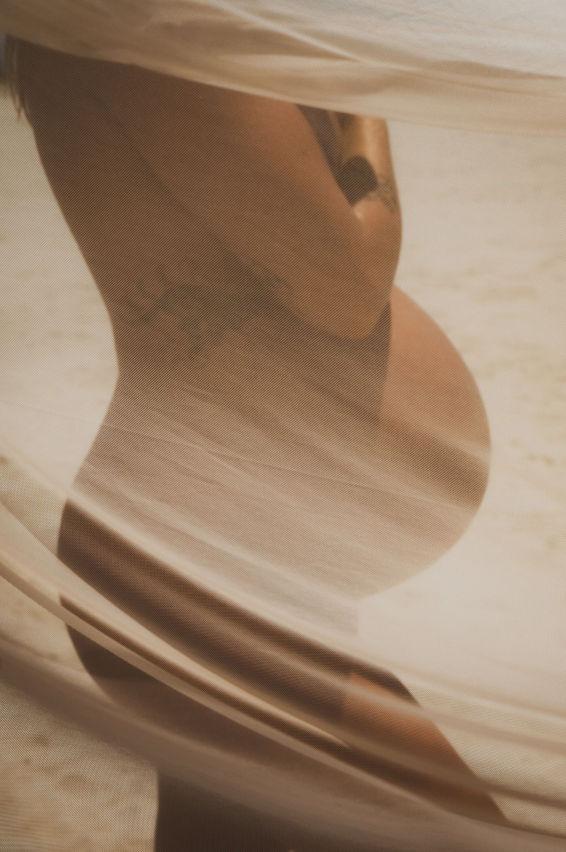 Abstract flowing fabric in sepia tones creating soft waves and folds.