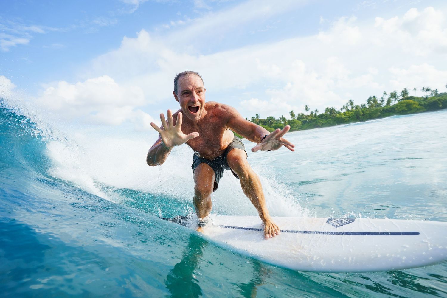 Action sequence of surfer riding blue ocean waves in tropical setting.