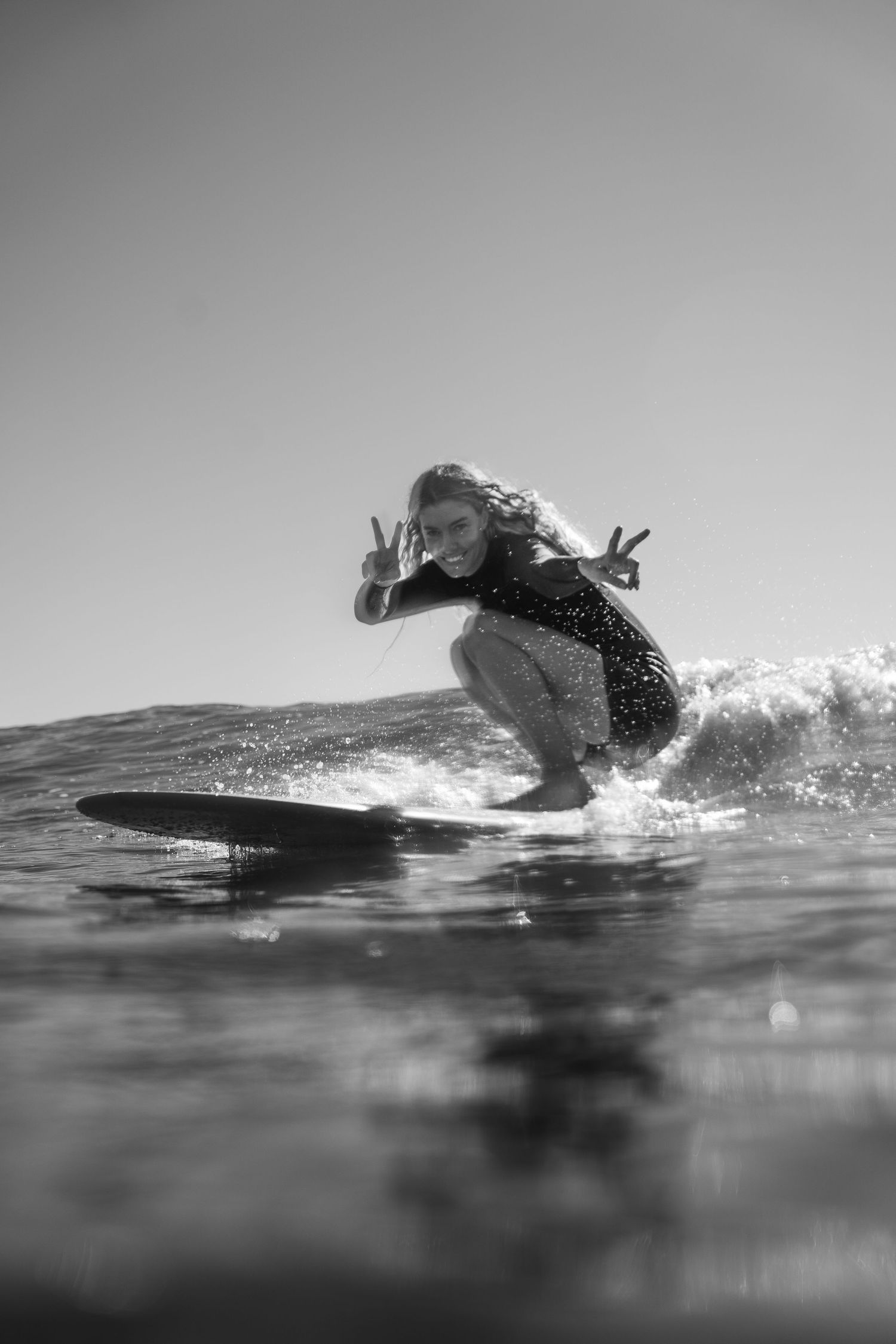 Black and white sequence of a surfer riding a wave in dynamic motion.