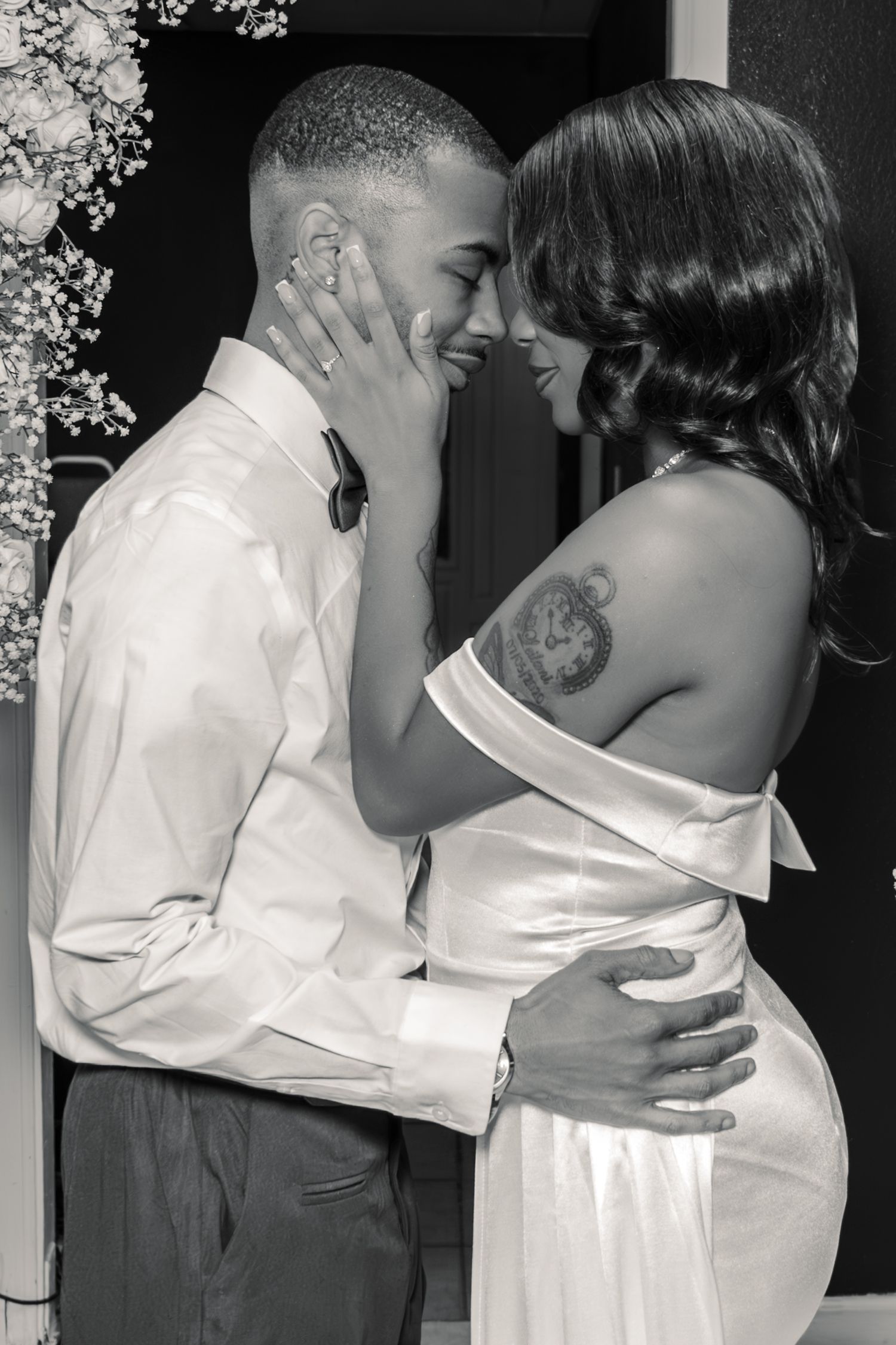 Black and white photo of a newlywed couple sharing an intimate moment, bride with shoulder tattoo.