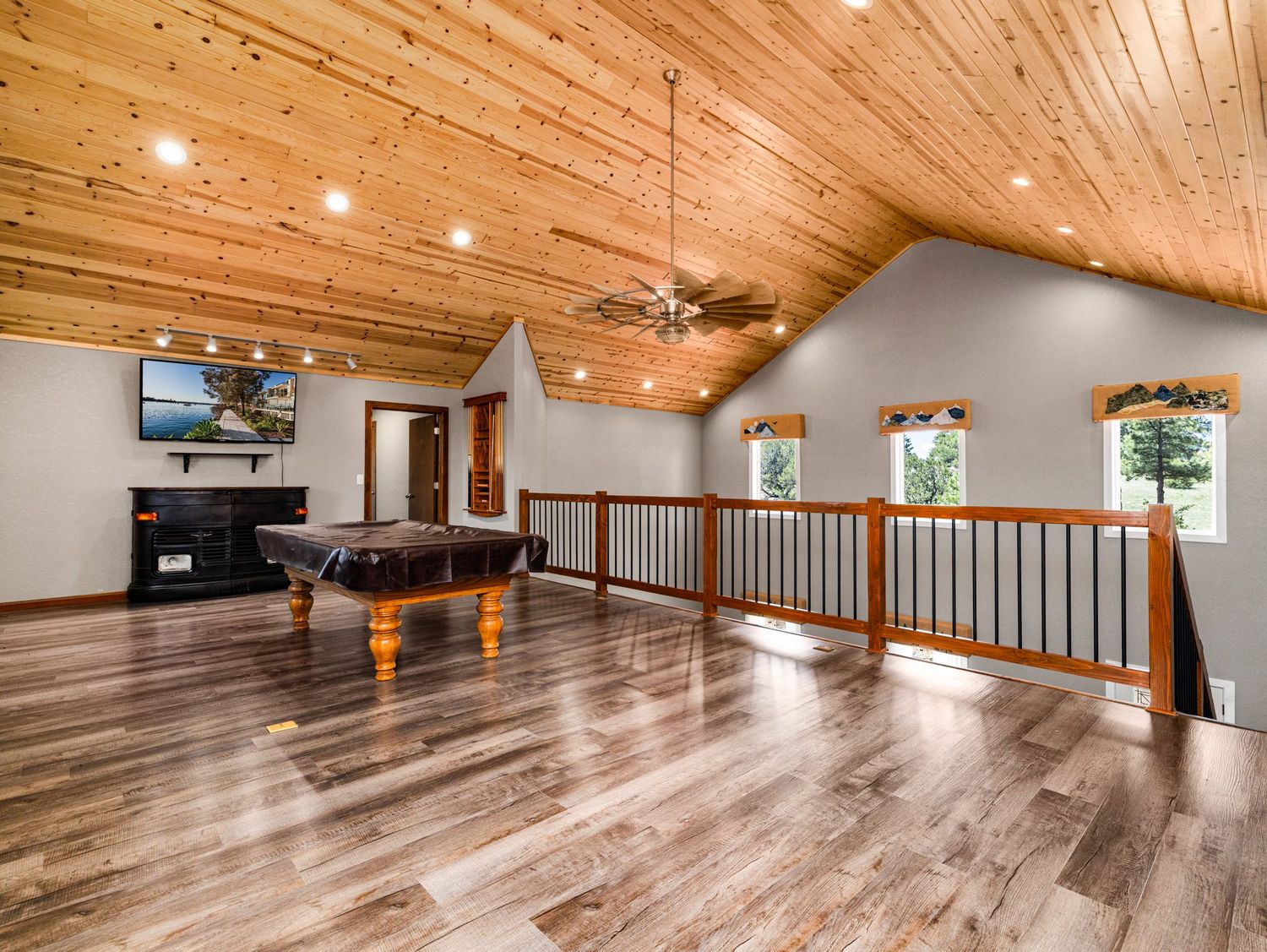 Large bonus room with vaulted wood ceiling, pool table, hardwood floors, and open loft railing.