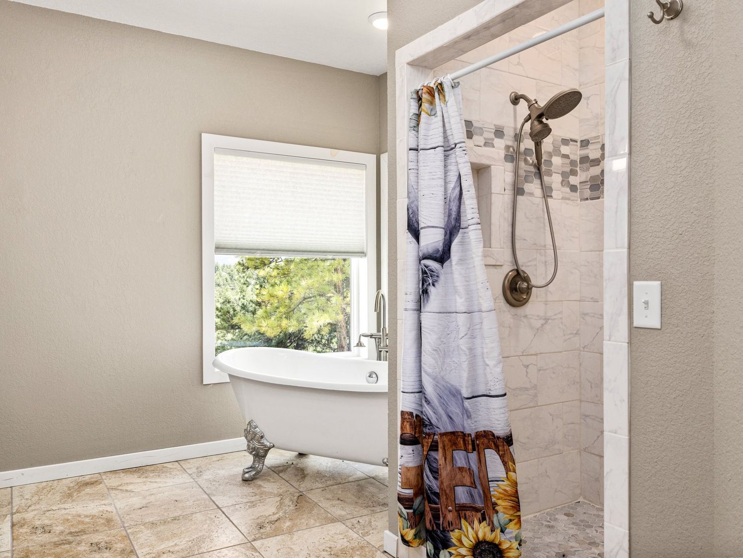 Master bathroom featuring a clawfoot soaking tub and walk-in tile shower with bronze fixtures.