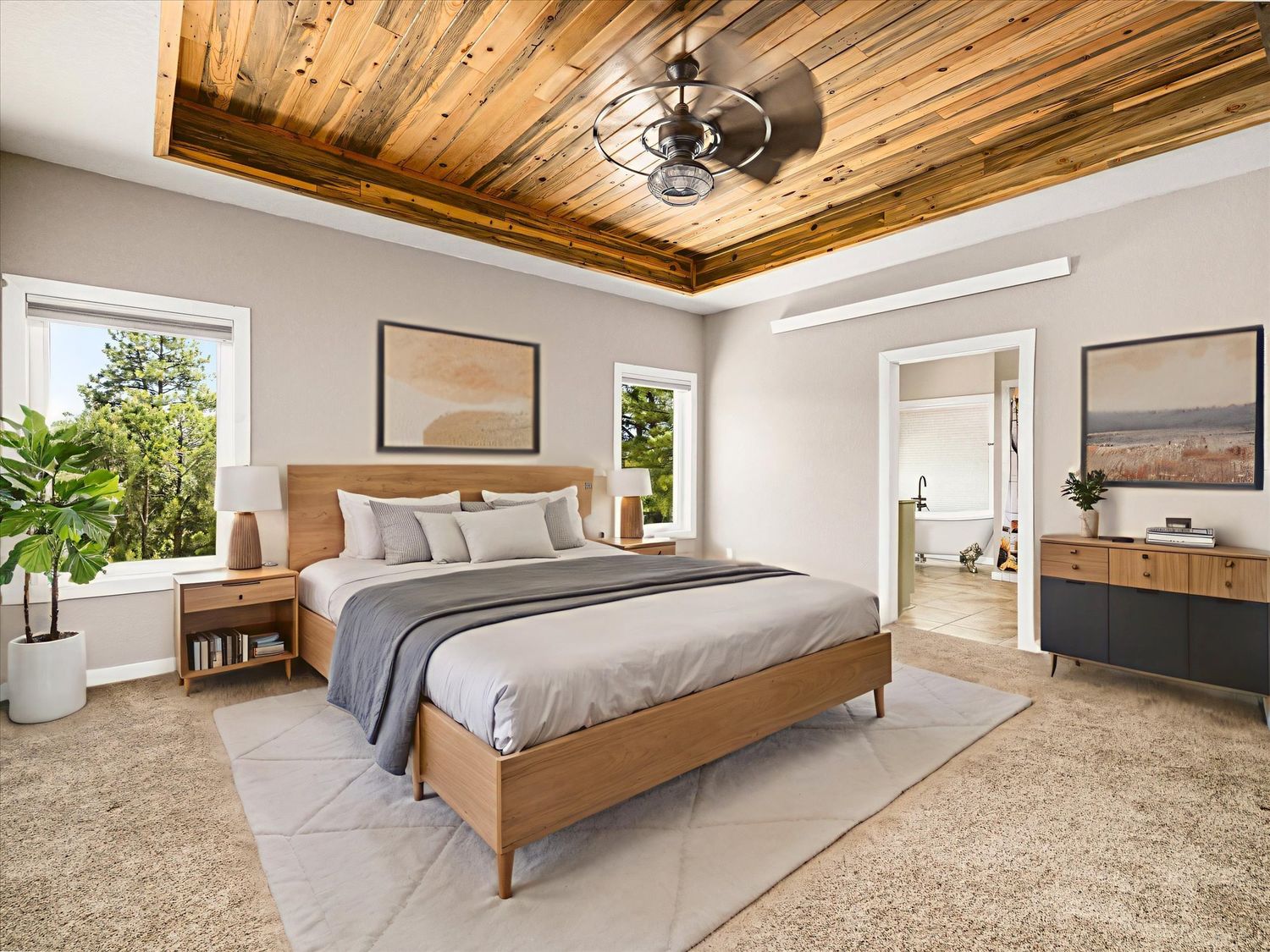 Elegant master bedroom with wooden tray ceiling, ceiling fan, neutral tones, and a king-sized bed on a light area rug.
