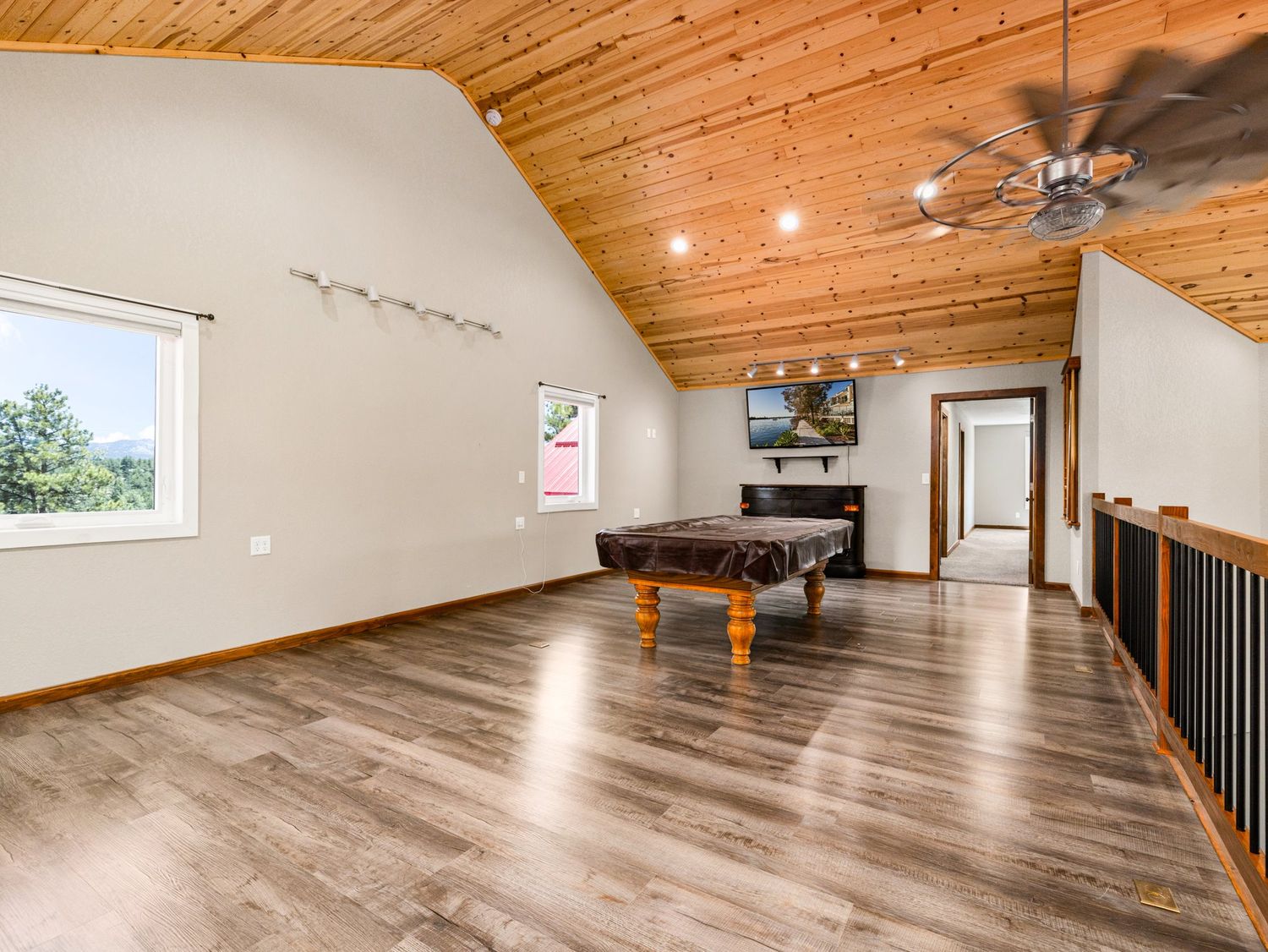 Loft game room with vaulted wood ceiling, hardwood floors, pool table, and ceiling fan.