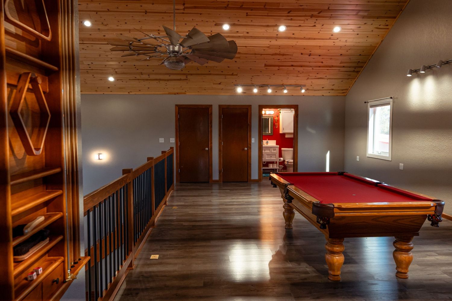 Game room with pool table, wooden ceiling, and decorative lighting fixtures.
