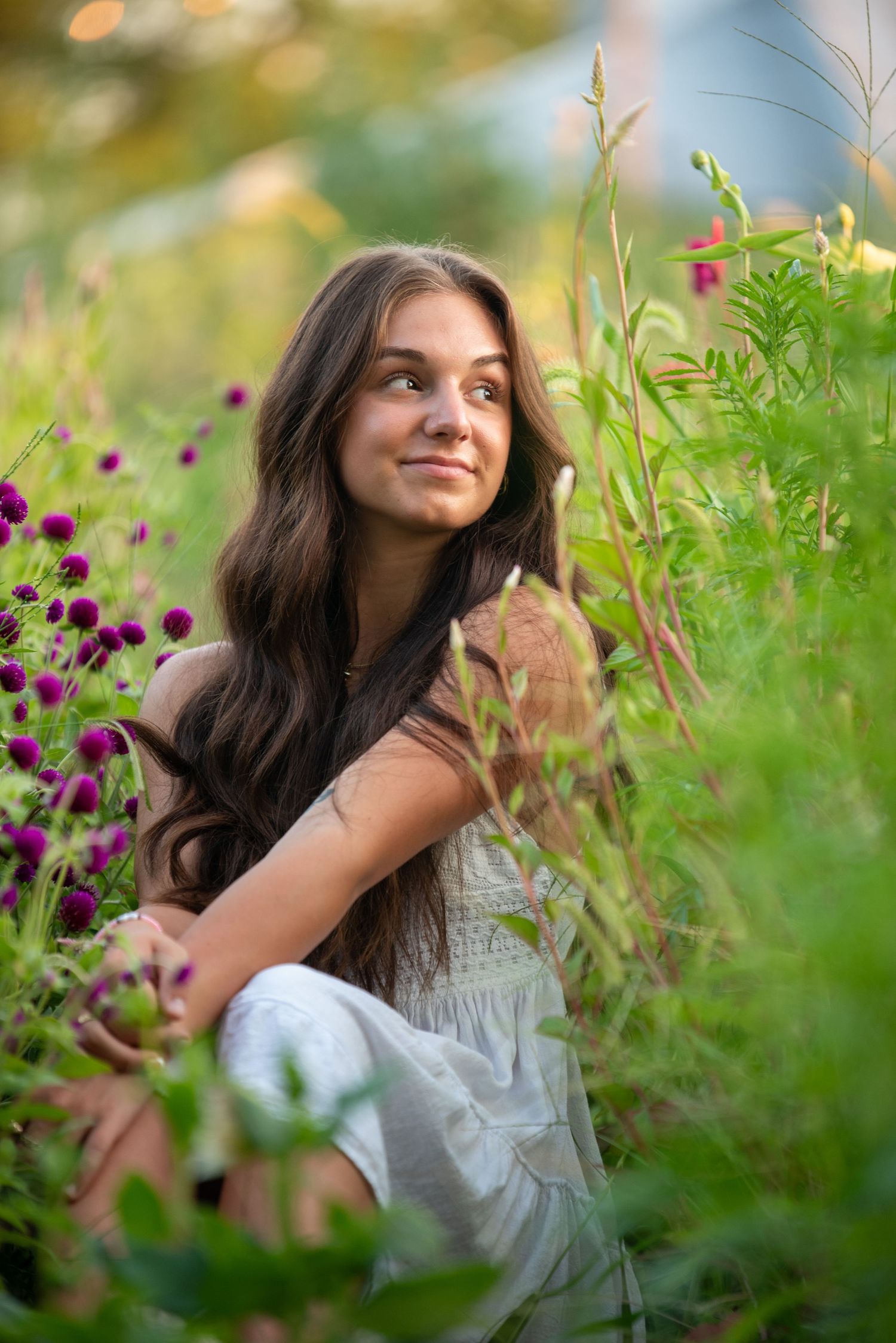 Artistic portrait series in a wildflower meadow with purple blooms during golden hour.