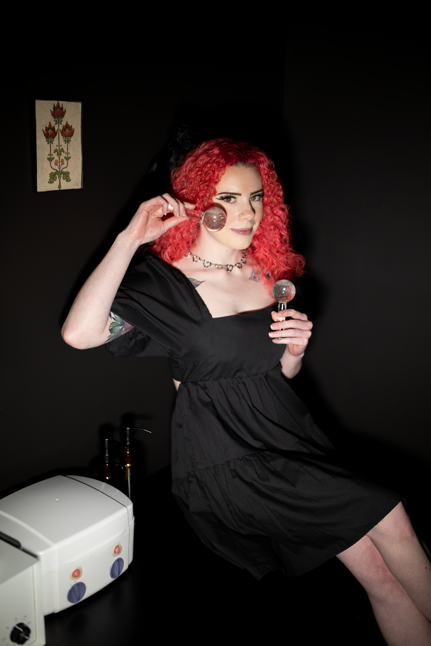 Series of photos showing someone in a black dress posing with a white box in a dark setting.