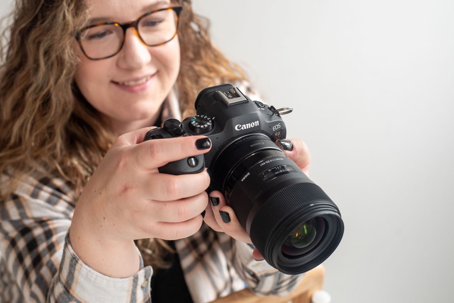 Close-up shots of someone examining a professional camera against white background.
