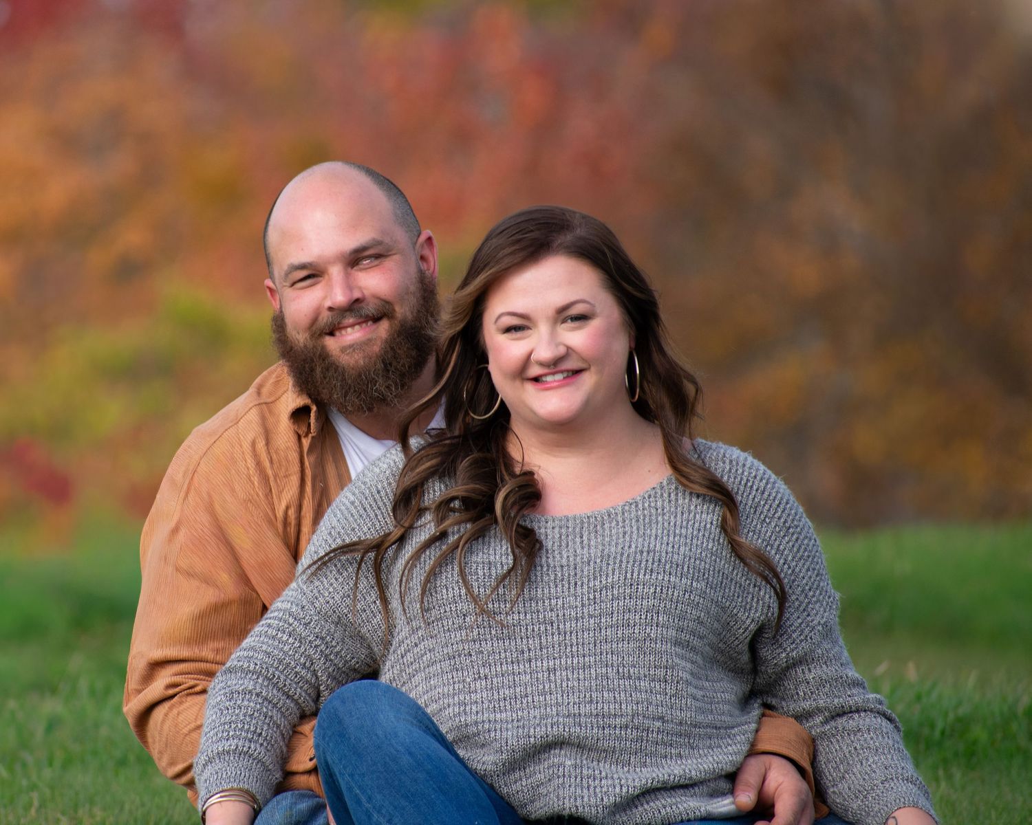 Casual outdoor portrait of couple in matching sweaters during autumn.