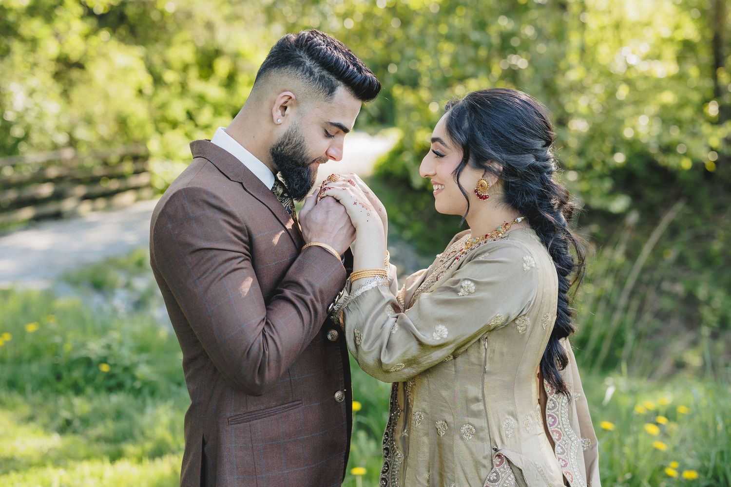 Romantic couple sharing an intimate moment in a sunlit garden setting.