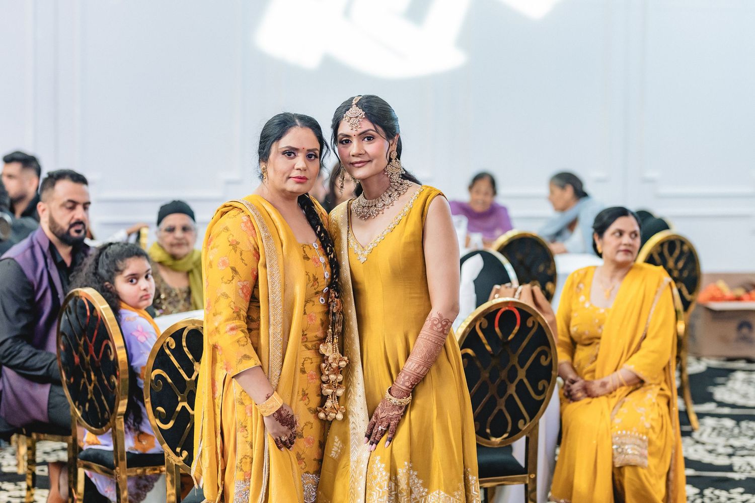 Group photo of wedding party members wearing coordinated yellow traditional Indian outfits.