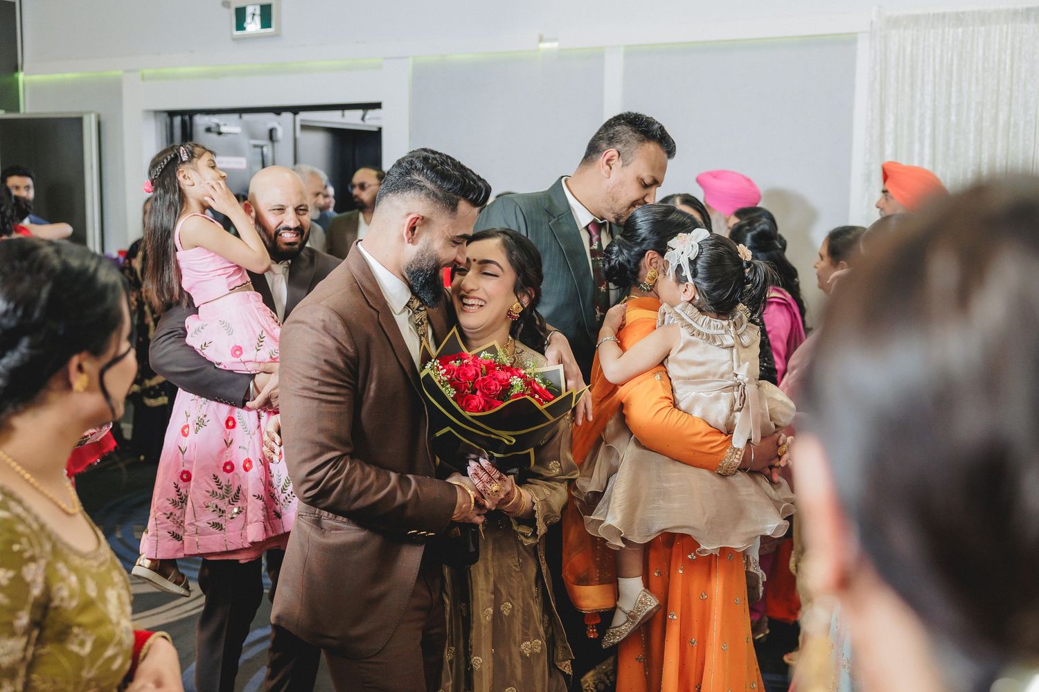 Indoor celebration with guests in colorful attire gathered for a special event.