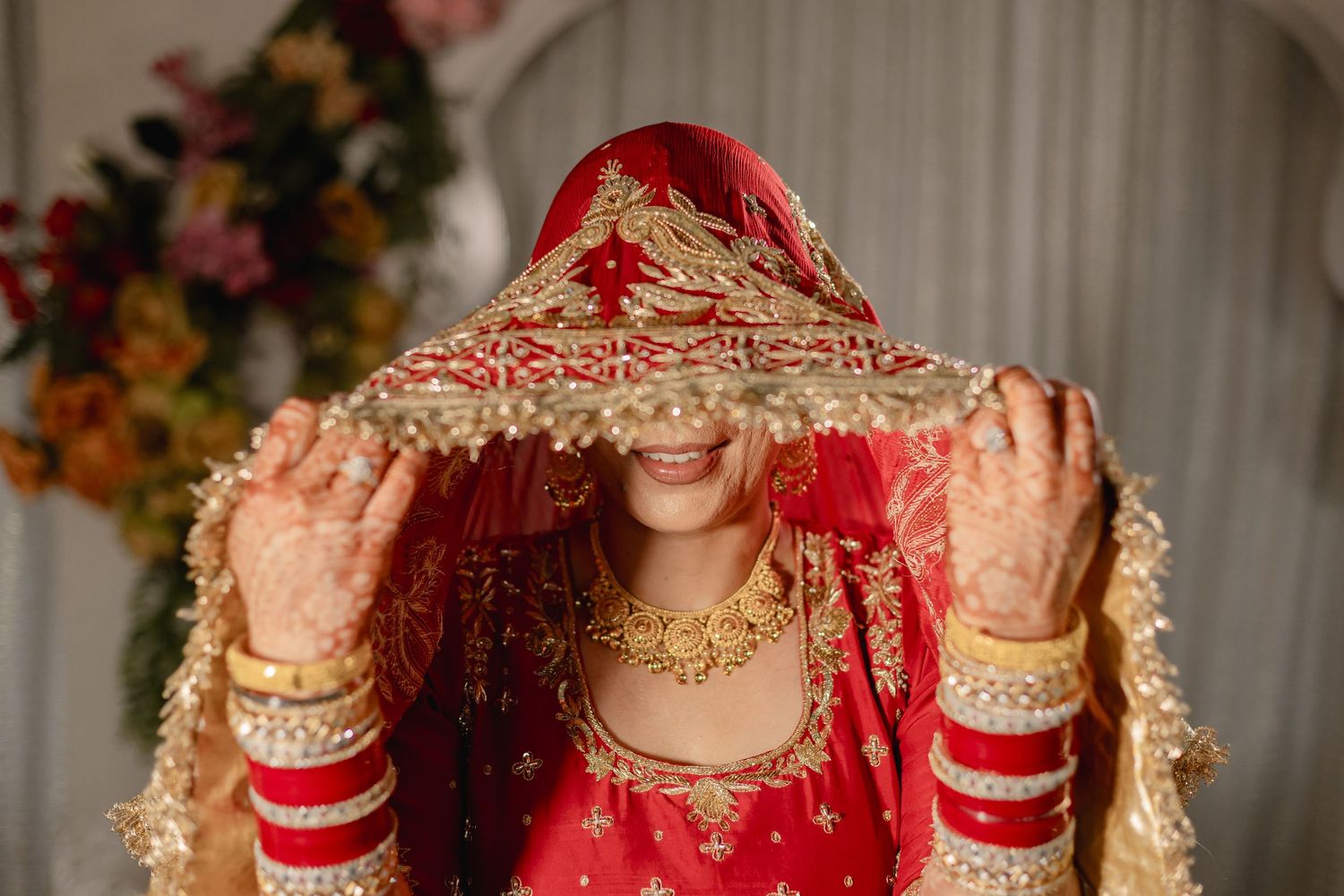 Traditional bridal jewelry and accessories with gold embellishments on red fabric.