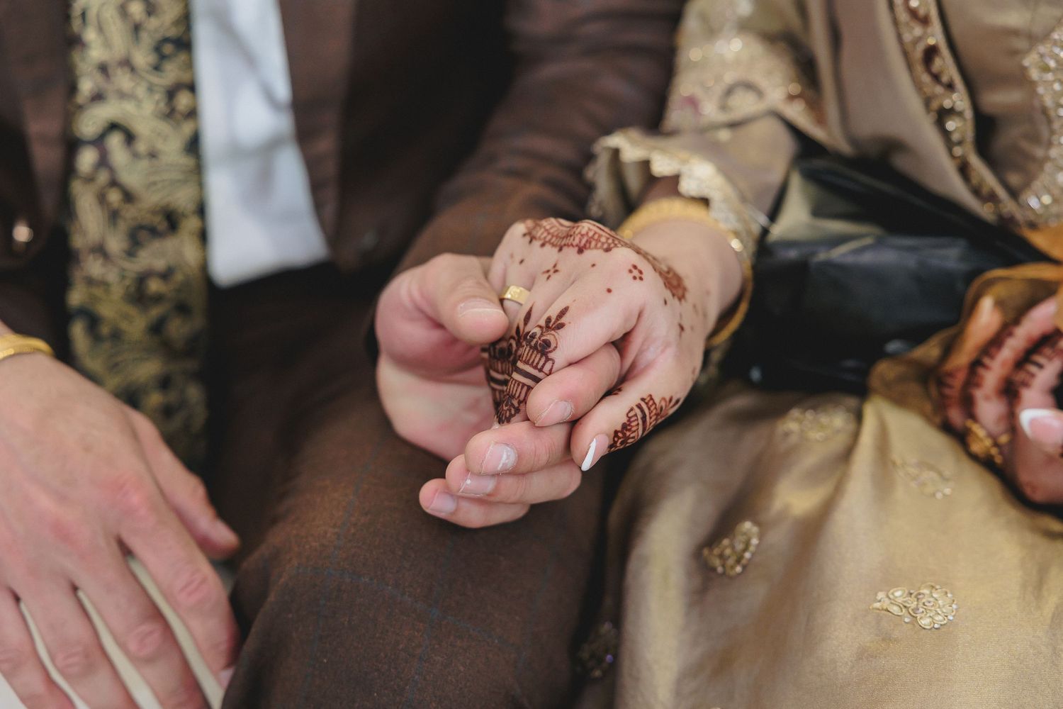 Close-up of hands exchanging rings during a traditional ceremony.