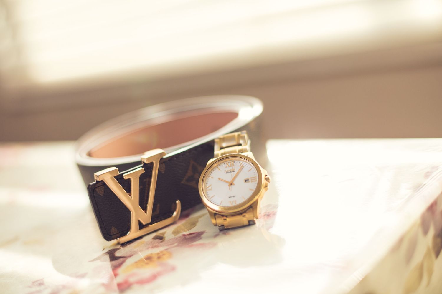 Elegant gold watch and accessories photographed in soft natural light.