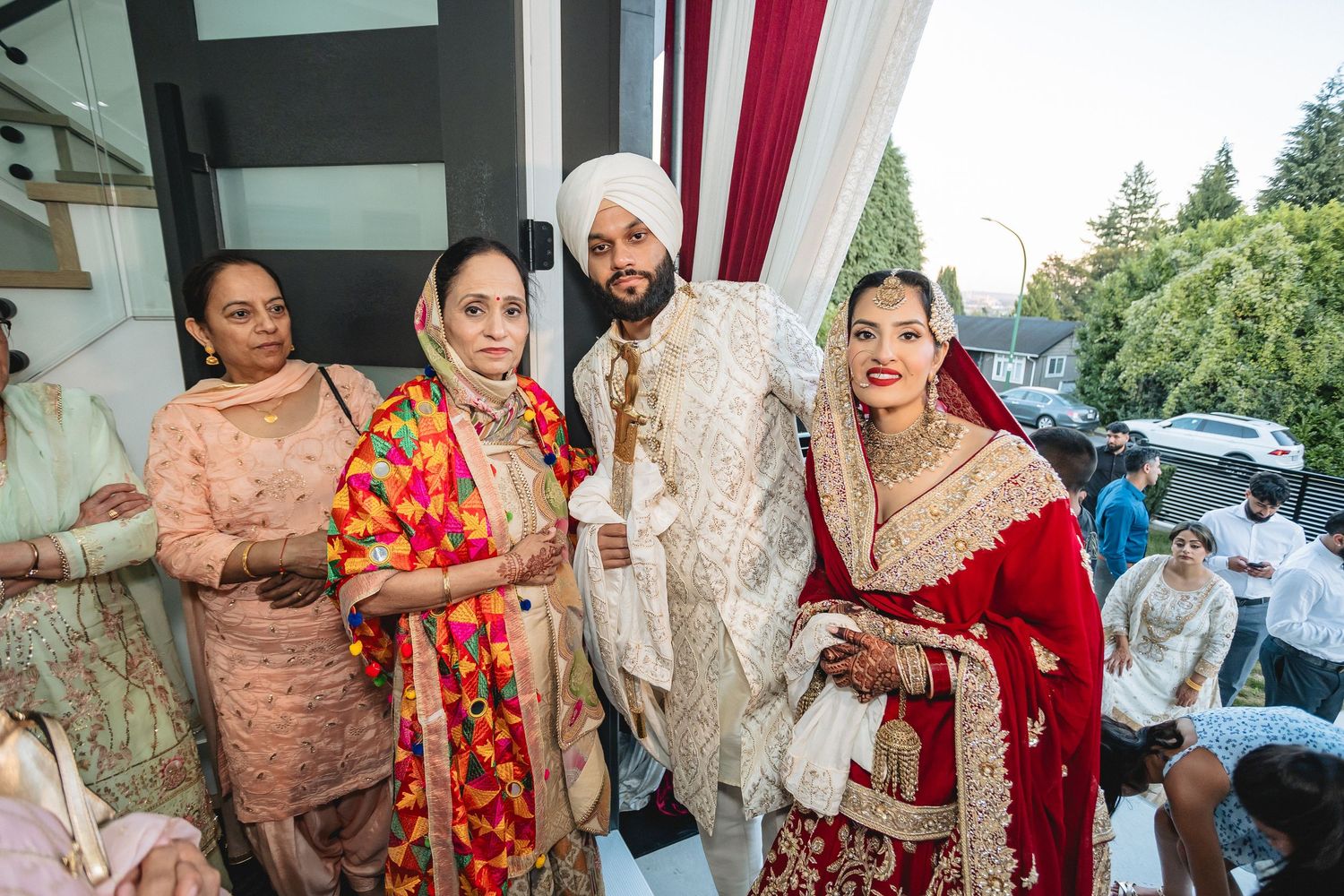 Wedding party members in traditional South Asian attire greeting and celebrating.