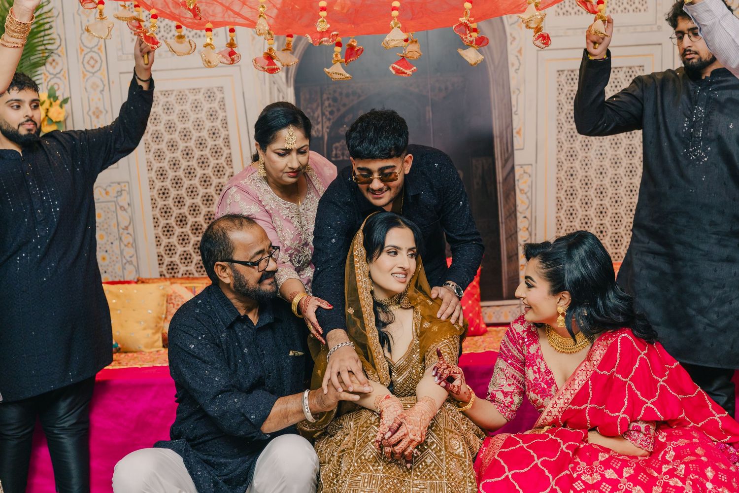 Celebratory dance scene with red lighting and traditional Indian decor.
