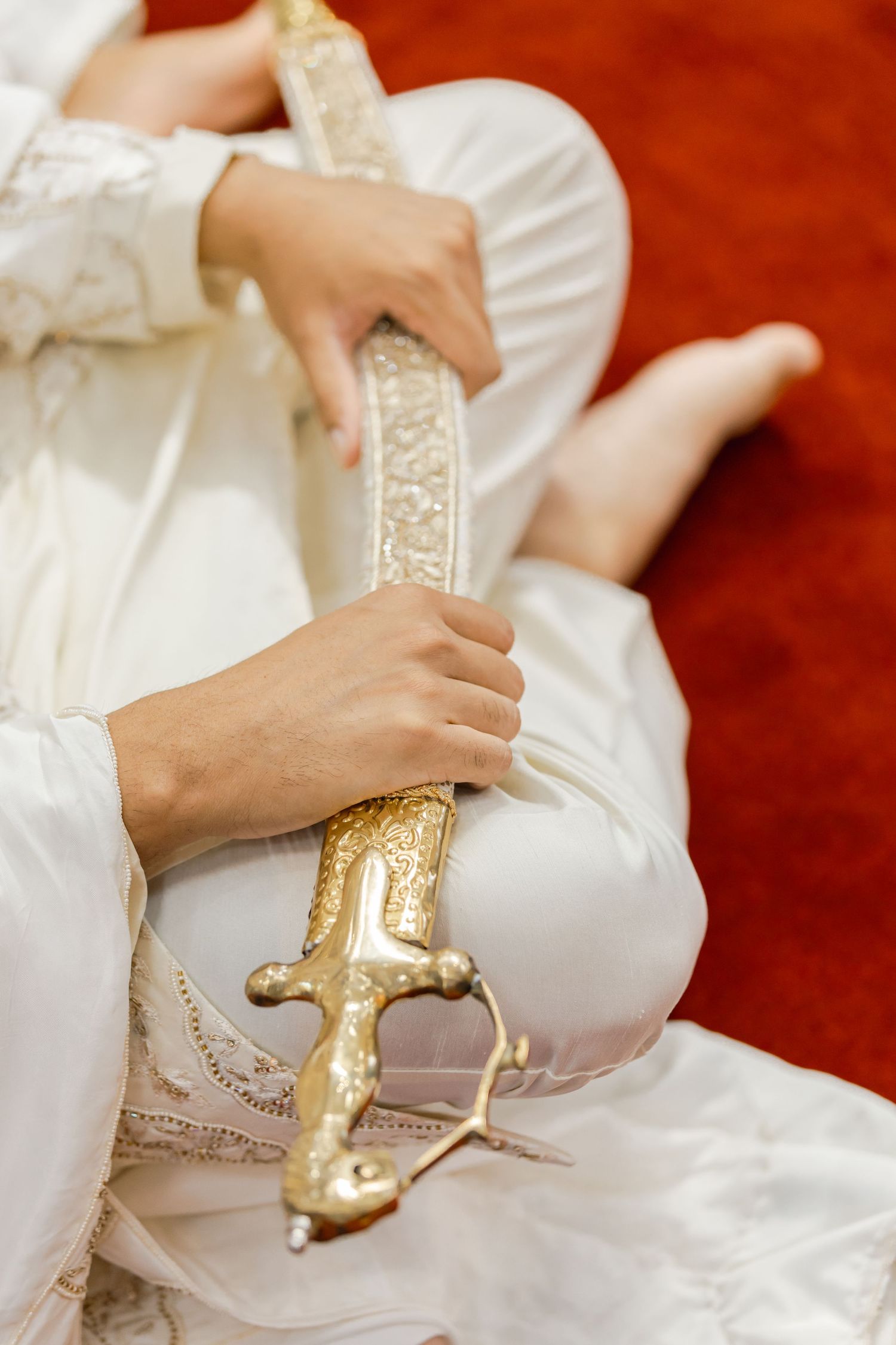 Close-up shots of gold embellished shoes being put on against white fabric and red carpet.
