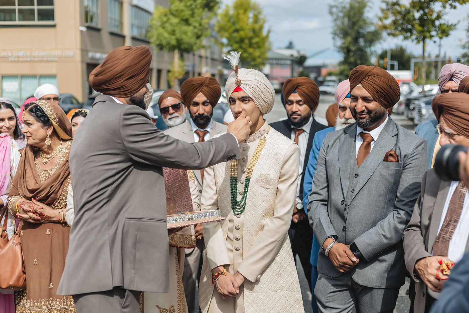 Wedding guests gathered outdoors in traditional Indian attire during a sunny celebration.