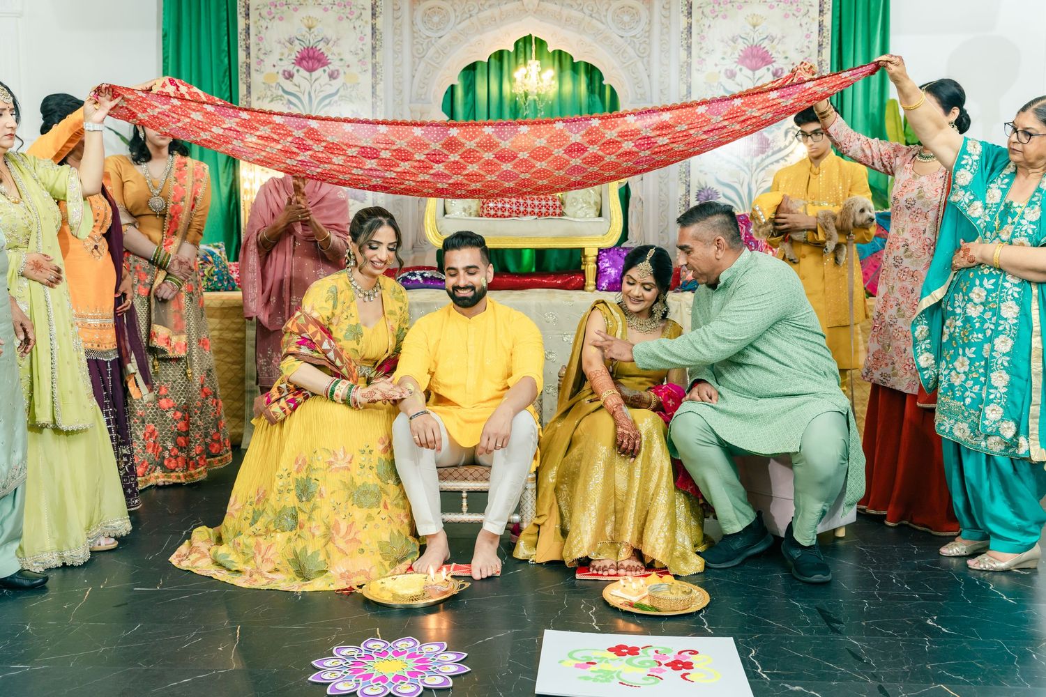Traditional celebration with decorative elements including green drapes and guests in vibrant yellow attire.