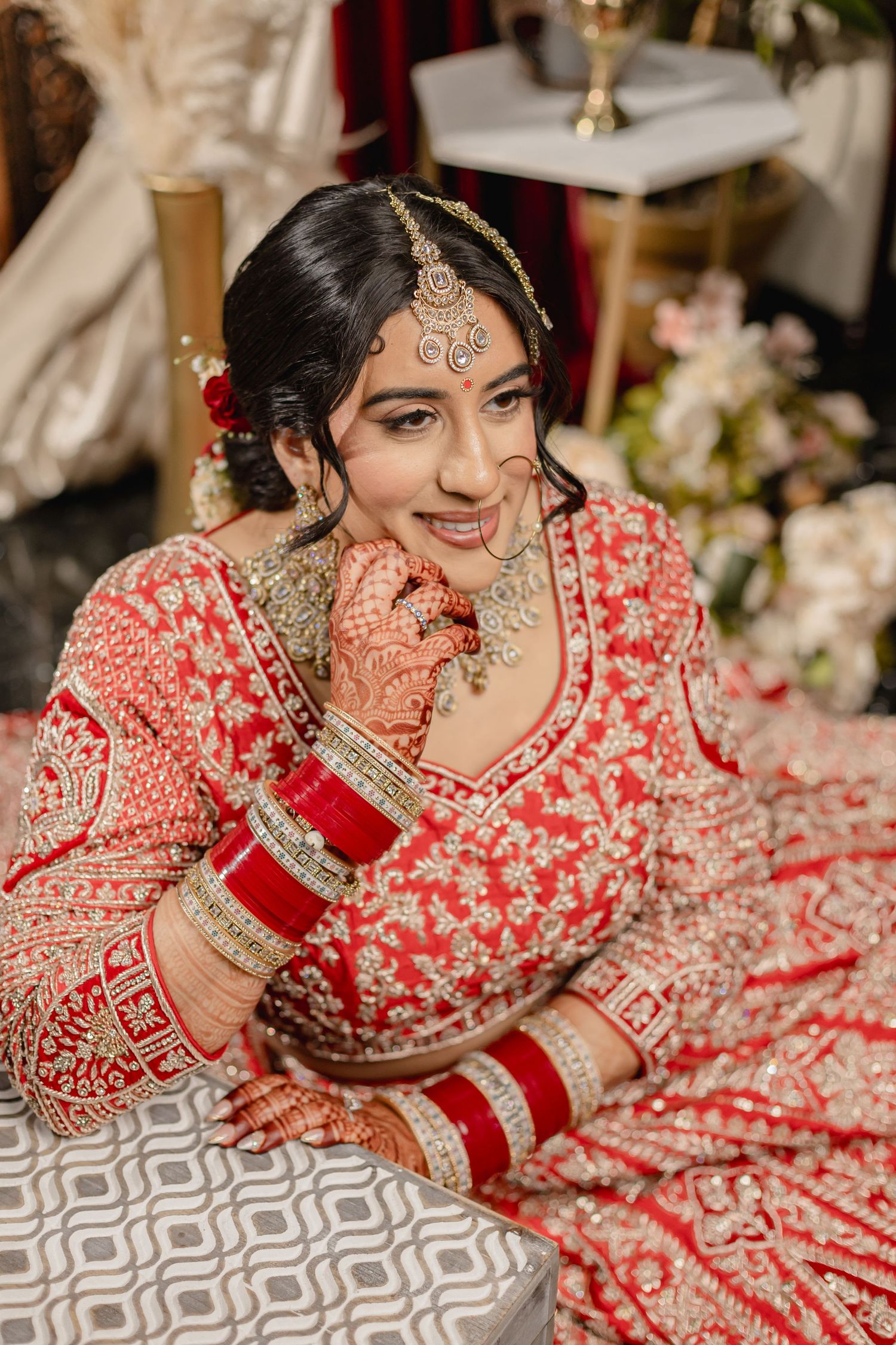Detailed view of red and gold embroidered bridal lehenga with intricate traditional Indian designs.