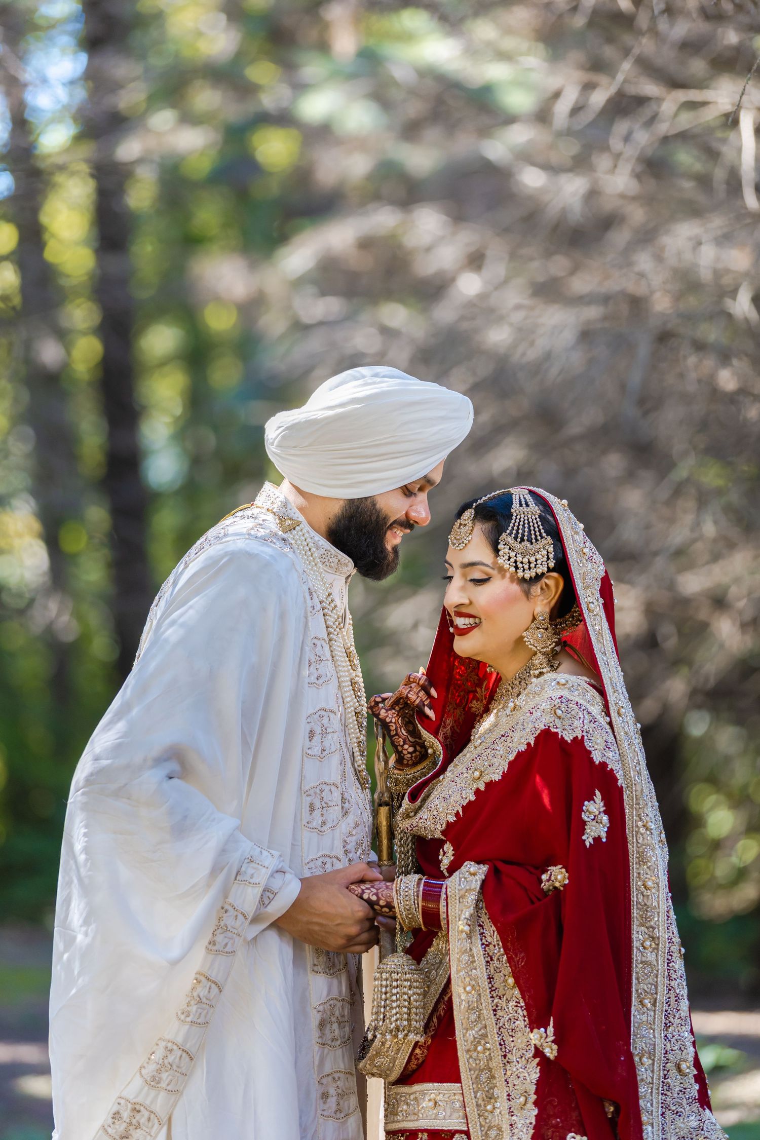 Traditional Sikh wedding ceremony with couple in ornate red and white ceremonial attire.