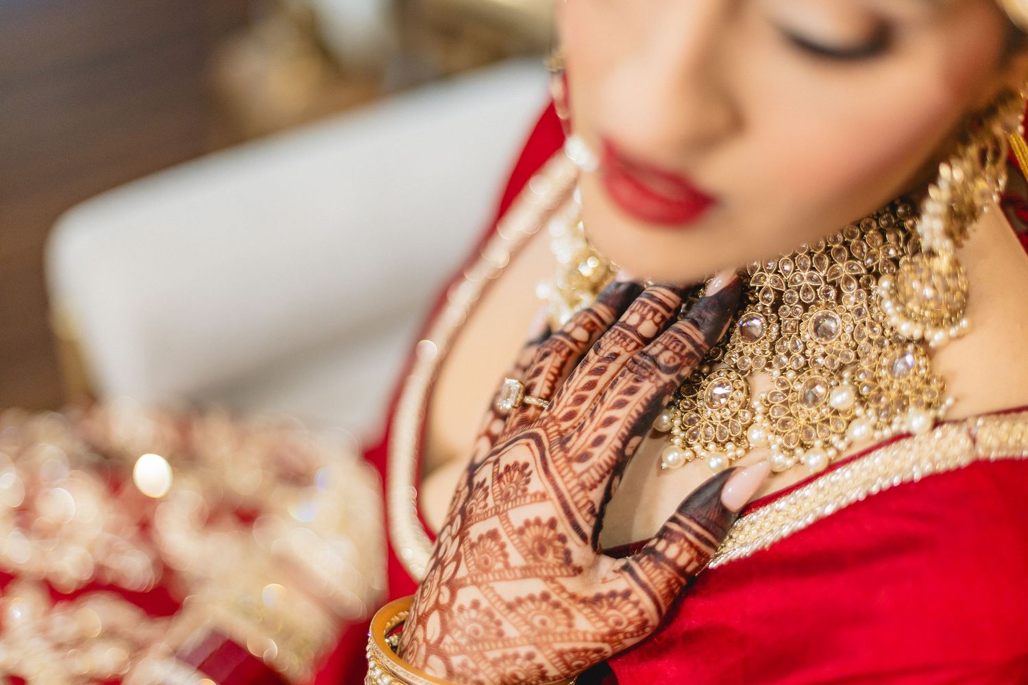 Detailed shot of traditional Indian bridal makeup and jewelry with red accents.