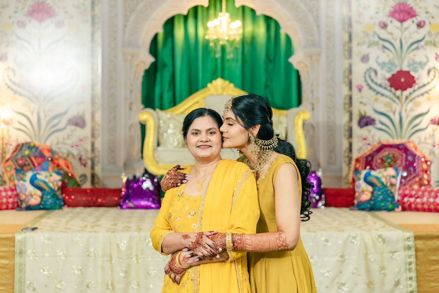 Wedding celebration scene with decorative backdrop featuring ornate green archways and festive lighting.